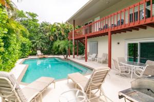 una piscina con sedie e un tavolo su un patio di A Wright Place a Holmes Beach