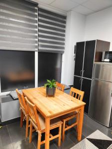 a kitchen with a wooden table with chairs and a refrigerator at Slate Apartament Jedlina - Zdrój in Jedlina-Zdrój