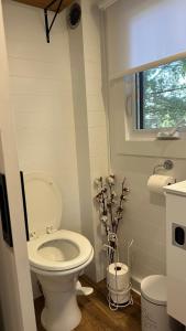 a small bathroom with a toilet and a window at Micro chalet Le Boisé ! in Saint Zenon