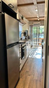 a kitchen with a large stainless steel refrigerator at Micro chalet Le Boisé ! in Saint Zenon +25 photos
