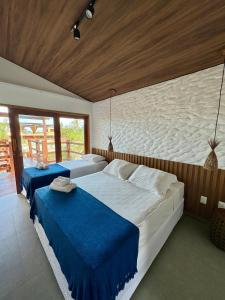 a bedroom with two beds with blue sheets at Pousada Lá em Casa in Barra Grande