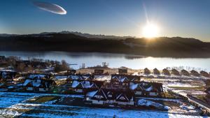 um avião sobrevoando uma aldeia com telhados cobertos de neve em Pensjonat u Słodyczki em Kluszkowce