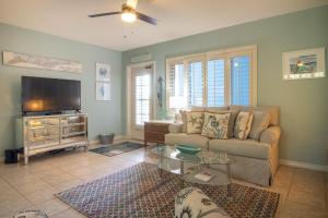 Una sala de estar con un sofá y un televisor de pantalla plana. en Anna Maria Beach Place, Unit 5, en Holmes Beach