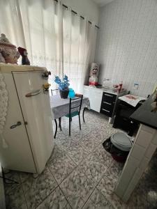 a kitchen with a refrigerator and a table at A CASA DE IRENE II in Aparecida