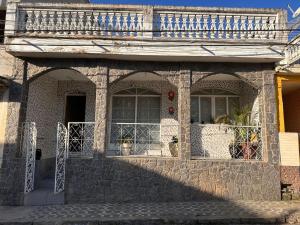 uma casa de pedra com duas janelas e uma varanda em A CASA DE IRENE II em Aparecida