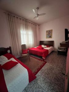 a bedroom with two beds and a ceiling fan at A CASA DE IRENE II in Aparecida