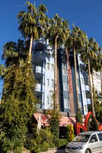 a building with palm trees in front of it at Comfort Suites in Alanya