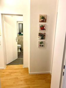 a hallway with a bathroom with a toilet and pictures on the wall at Schöne Wohnung im Herzen von Miltenberg in Miltenberg