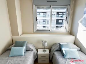 two beds in a small room with a window at Una Mirada al Alba in Cabanes