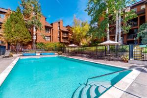 Una piscina con sillas y sombrillas al lado de un edificio. en Timber Run, en Steamboat Springs 14 fotos más