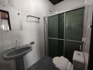 a bathroom with a shower and a sink and a toilet at Pousada Tropicália Tranquilidade a Beira Mar in Santa Cruz Cabrália