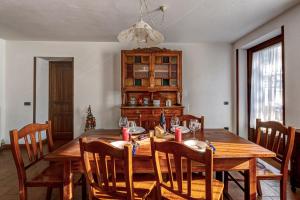 a dining room with a wooden table and chairs at CHALET PONTAL 3 - Relax e vista sulle montagne - COUR 0142 in Courmayeur