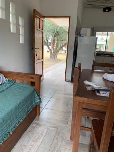 1 dormitorio con cama, escritorio y mesa en 12 Olivos Cabañas en San Rafael