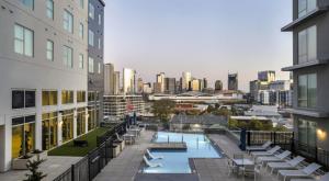 a building with a swimming pool and a city skyline at The Bel Air Suite Penthouse The Gulch in Nashville