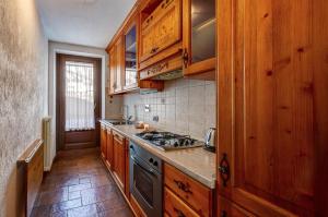 a kitchen with wooden cabinets and a stove top oven at CHALET PONTAL 3 - Relax e vista sulle montagne - COUR 0142 in Courmayeur
