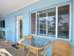 Un patio con una mesa y sillas y una ventana. en Anna Maria Beach Place, Unit 6, en Holmes Beach