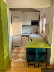 a kitchen with a green counter and two stools at Silicon Valley studio in Belgrade
