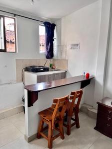 una cocina con 2 sillas de madera en un mostrador en Acogedor Apartaestudio en el Centro de Pereira, en Pereira