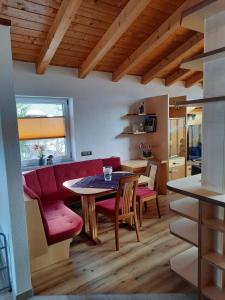 a living room with a red couch and a table at Haus am Römerweg in Lermoos