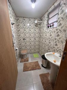 uma casa de banho com um lavatório e um WC em A CASA DE IRENE em Aparecida