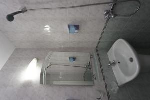 La salle de bains est pourvue de toilettes, d'un lavabo et d'un miroir. dans l'établissement Hotel Marina, à Kiten