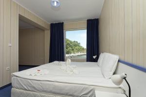 una camera da letto con un grande letto bianco e una finestra di Hotel Marina a Kiten