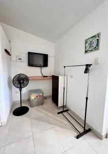 um quarto com uma televisão de ecrã plano e uma ventoinha em Acogedor Apartaestudio en el Centro de Pereira em Pereira