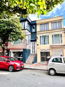 dos autos estacionados frente a una casa en Acogedor Apartaestudio en el Centro de Pereira, en Pereira