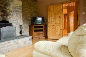 - un salon avec un canapé et une cheminée dans l'établissement The Mountain Lodge Slievenamon spacious 4 bedroom house, à Cloneen