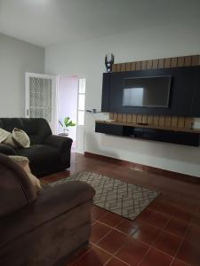 ein Wohnzimmer mit einem Sofa und einem Flachbild-TV in der Unterkunft Casa Temporada Espaço Vip in Barra do Garças