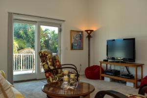 a living room with a flat screen tv and a table at Lakeside Beach House in Holmes Beach