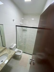 ein Badezimmer mit einem WC und einer Glastür in der Unterkunft Casa Temporada Espaço Vip in Barra do Garças