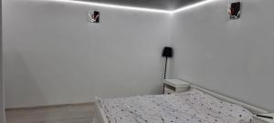 biała sypialnia z łóżkiem i 2 światłami w obiekcie Roman Residence w mieście Roman
