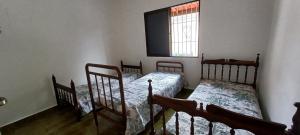 two beds in a room with a window at Casa Praia Mongaguá in Mongaguá