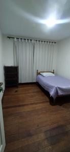 1 dormitorio con 1 cama y suelo de madera en Casa Zapata en Cochabamba