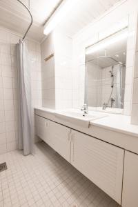 Baño blanco con lavabo y espejo en 2ndhomes Central & Cozy 1 BR Apartment in Kaisaniemi en Helsinki