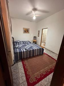 een slaapkamer met een bed en een plafondventilator bij A CASA DE IRENE I in Aparecida