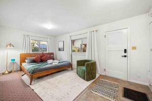 een woonkamer met een bed en een groene stoel bij Stylish 1920s Downtown Flagstaff unit with HotTub in Flagstaff