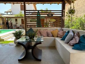 a couch with pillows and a table on a patio at Villa Paradiso Buzios in Búzios