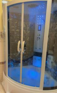 uma casa de banho com chuveiro e piso azul em Kyan Abha Hotel - فندق كيان ابها em Abha