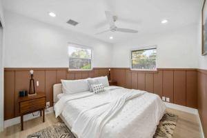 a bedroom with a large bed and two windows at Heart of Uptown retreat estate with views and hot tubs in Sedona