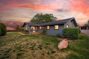 a house with a large rock in the yard at Heart of Uptown retreat estate with views and hot tubs in Sedona