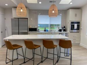 a kitchen with a large white counter and chairs at Uptown Vacation Villa at The OZ with Hot tub and Views in Sedona