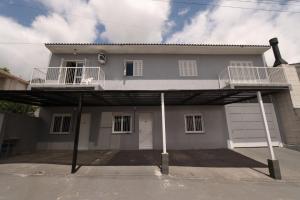 una gran casa blanca con garaje en Apartamento Completo e Confortável em Bento 02, en Bento Gonçalves