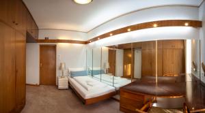 Cette grande chambre dispose d'une baignoire et d'un canapé blanc. dans l'établissement Innsbruck Garden Residence, à Innsbruck