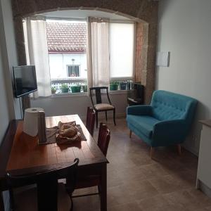 sala de estar con mesa y sofá azul en Habitación acogedora en casa de piedra, en Vigo