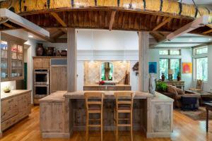 una cocina con una gran isla de madera con taburetes de bar en Riverfront Rainbow Bend Estate with Hot Tub, en Ketchum