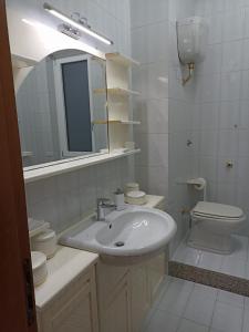 een badkamer met een wastafel, een toilet en een spiegel bij Casa Rossi in Pomigliano dʼArco