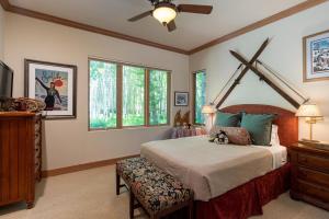 Schlafzimmer mit einem großen Bett mit einem Kopfteil aus Holz in der Unterkunft Riverfront Rainbow Bend Estate with Hot Tub in Ketchum