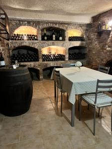bodega con mesa, sillas y botellas de vino en Cascina il Volo en Moncalvo